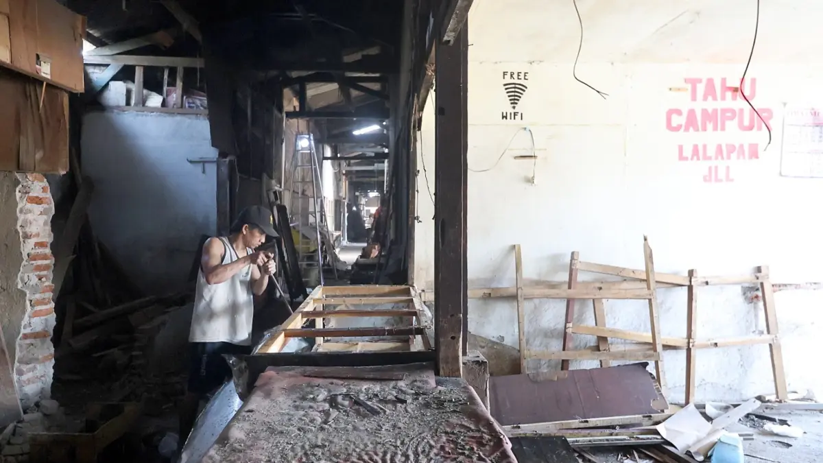 DEADLINE HARI INI: Salah satu pedagang mencicil proses pembongkaran lapaknya, kemarin. Mereka bakal pindah ke tempat relokasi. (Darmono/Radar Malang)