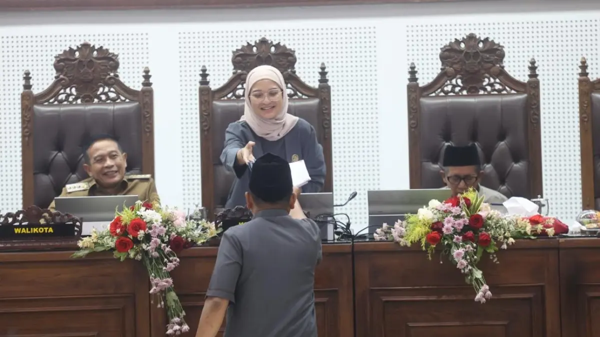 PEMBAHASAN RAMPUNG: Didampingi Wali Kota Malang Wahyu Hidayat, Ketua DPRD Kota Malang Amithya Ratnanggani Sirraduhita menerima salinan pengesahan Ranperda APBD Perubahan 2026, kemarin. (Darmono/Radar Malang)