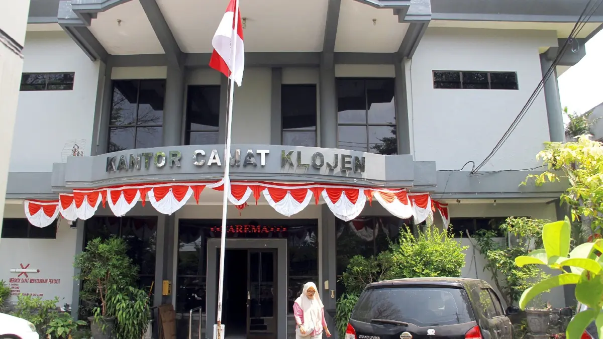 BERLAKU DI 5 KECAMATAN: Salah satu warga keluar dari Kantor Kecamatan Klojen setelah mengurus administrasi kependudukan, kemarin. (Darmono/Radar Malang)