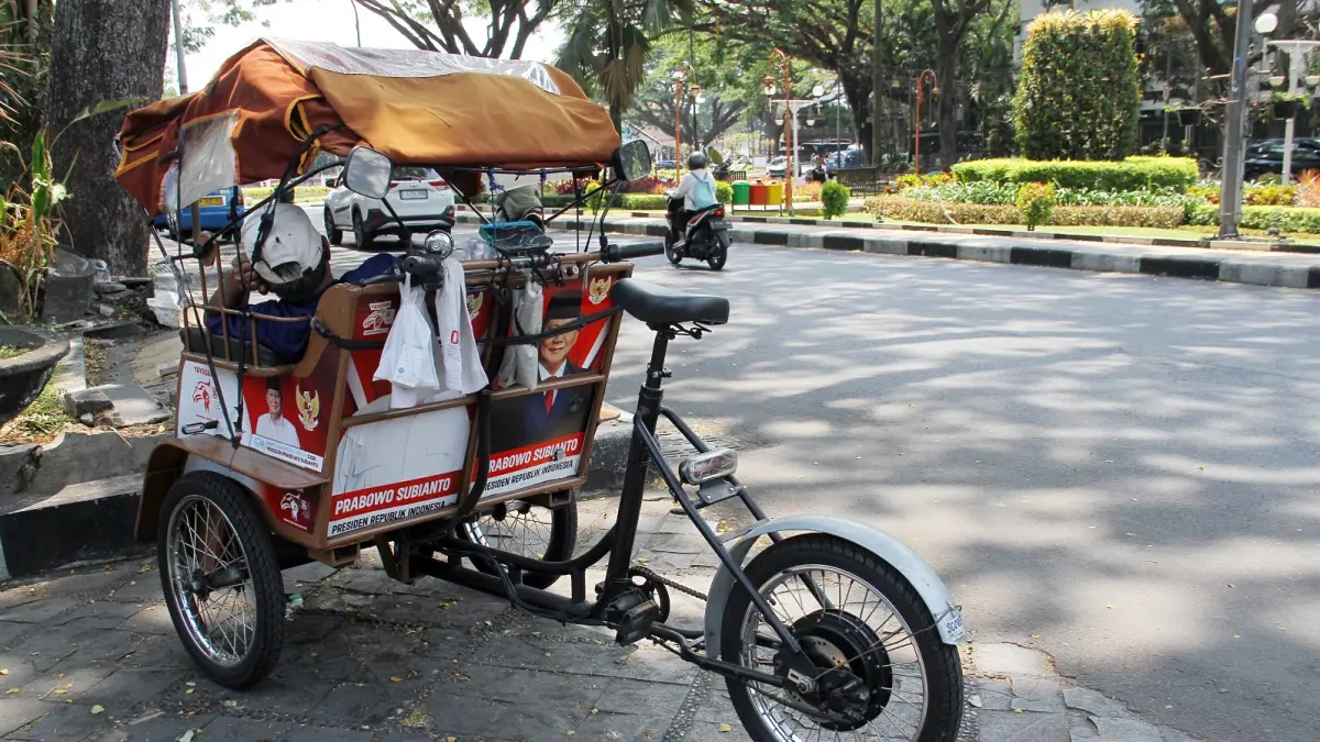 OPERASIONAL BELUM OPTIMAL: Salah satu pengemudi becak listrik menunggu penumpang di Jalan Kertanegara, Klojen, kemarin (17/9). (Darmono/Radar Malang)