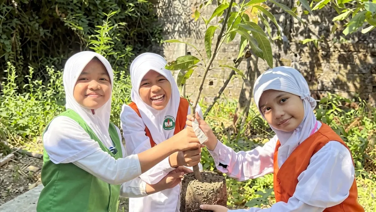 Murid Mi Ar Ridlo bersemangat menanam pohon mangga di Panti asuhan al Qorni.