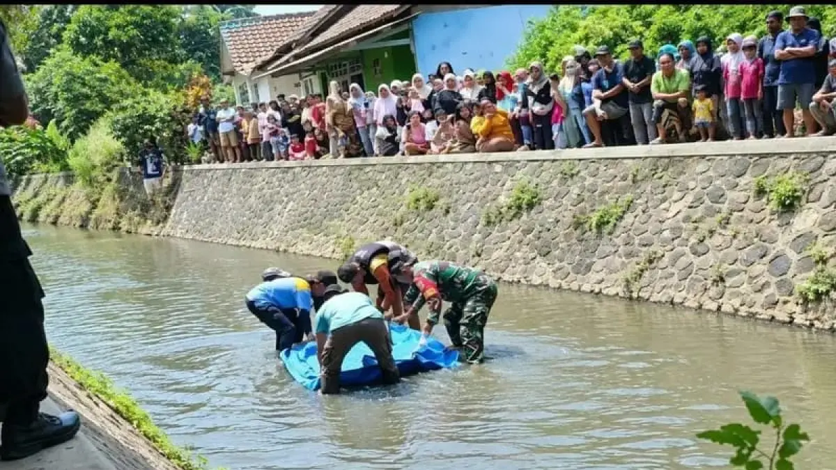 DALAMI PENYEBAB: Petugas mengevakuasi jenazah warga yang terhanyut di sungai Gading, Kecamatan Bululawang, Sabtu (19/9).