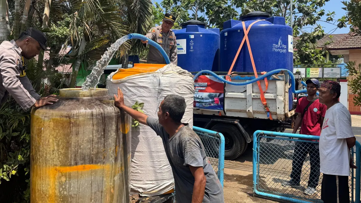 Petugas kepolisian menyalurkan bantuan air bersih di Kecamatan Sumberpucung, Rabu (23/9). (Humas Polres Malang)