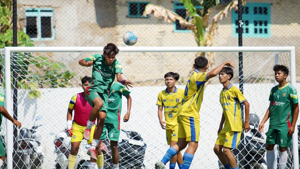 KETAT: Pemain MAN 2 Pamekasan (jersey hijau) menghalau bola atas saat mendapat serangan dari pemain-pemain SMAN 4 Pamekasan di Turnamen Bahlil Mini Soccer Asyik Menuju Puncak Zona 8 Madura di Puri Dewata Mini Soccer Pamekasan, Jumat sore (25/9). (FAHMI JALIL/RADAR MADURA)