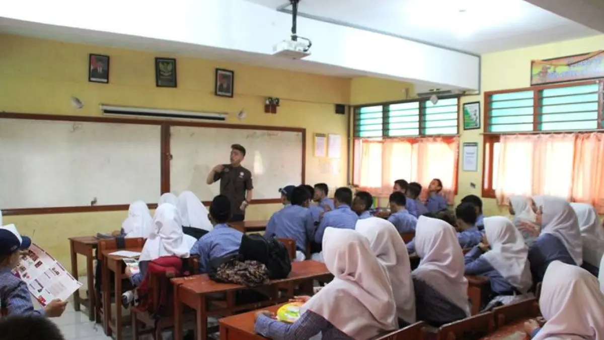 Ilustrasi pembelajaran kelas yang dipenuhi siswa.