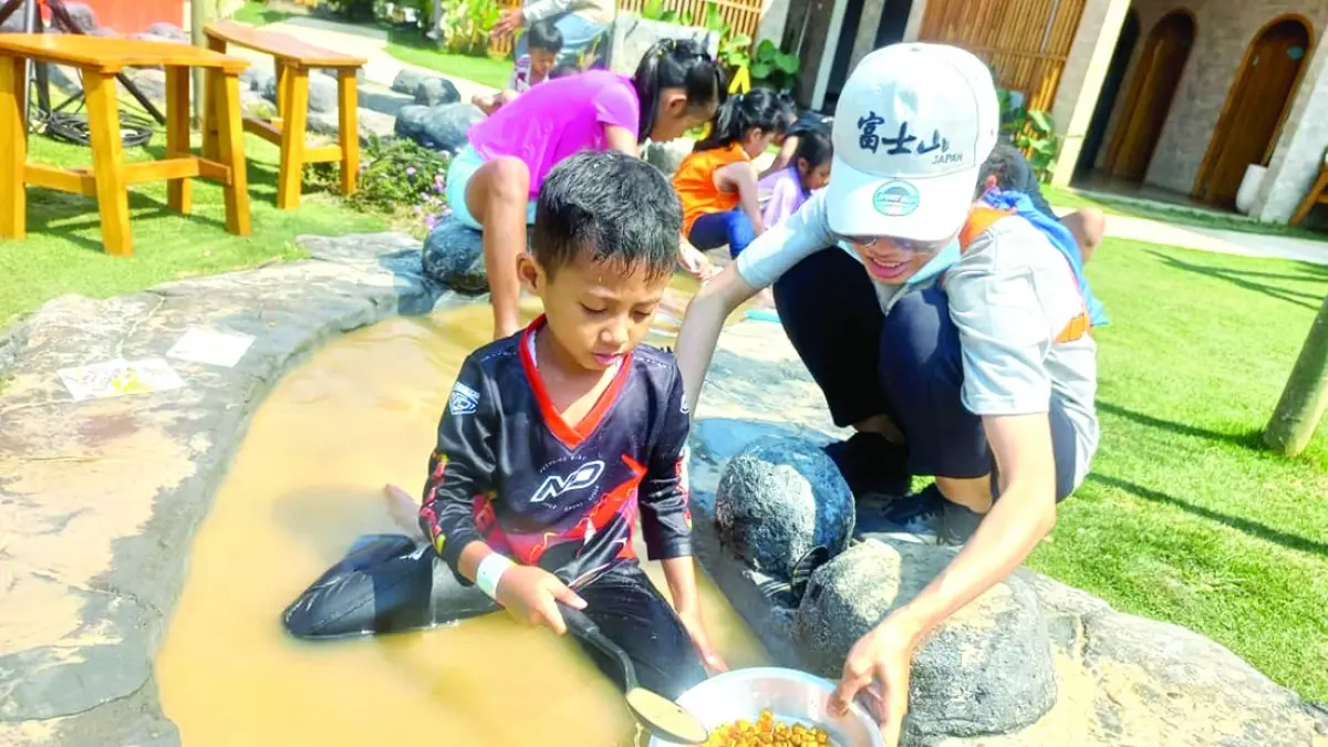 TAK TAKUT KOTOR: Seorang anak bersama orang tuanya melakukan eksperimen sembari bermain air di Kinville Sensory Park, The Araya Malang.