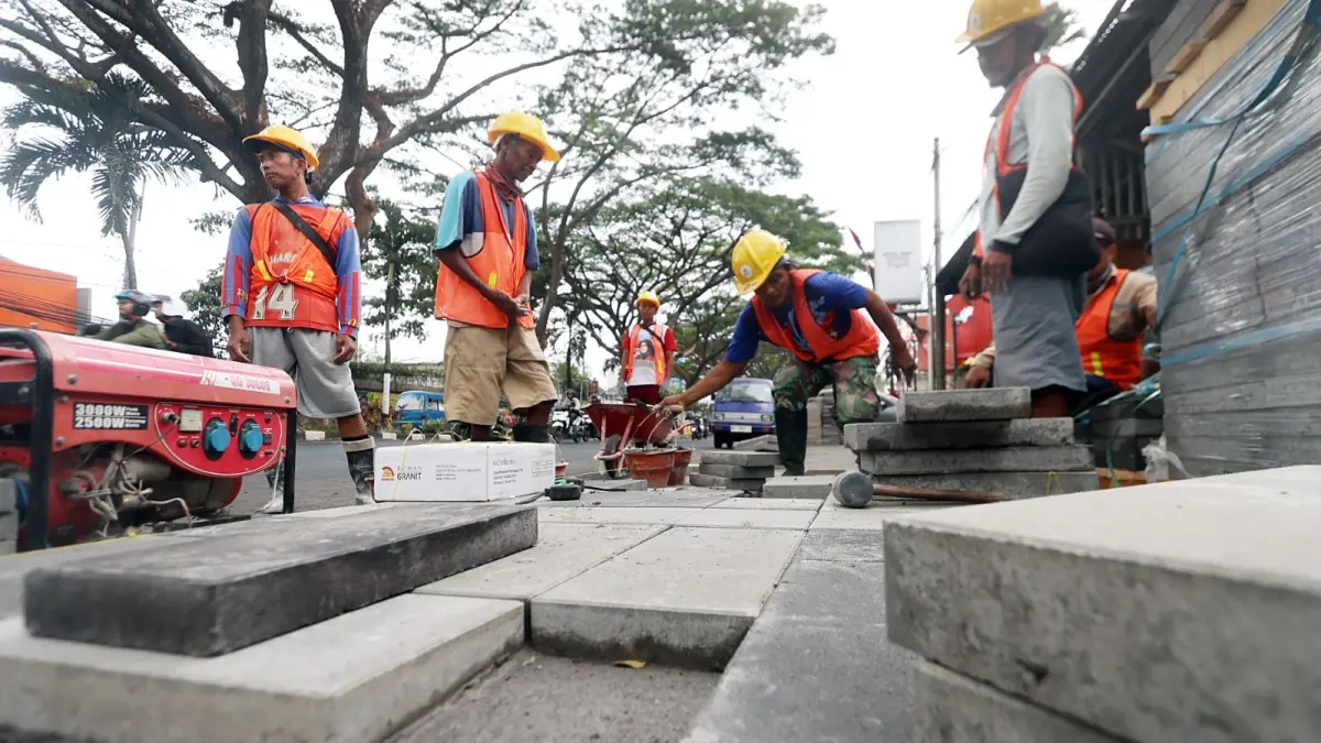 PANJANGNYA 1,3 KM: Sejumlah pekerja mengerjakan perbaikan trotoar di Jalan Soekarno-Hatta (Soehat), kemarin siang (30/9). (Darmono/Radar Malang)