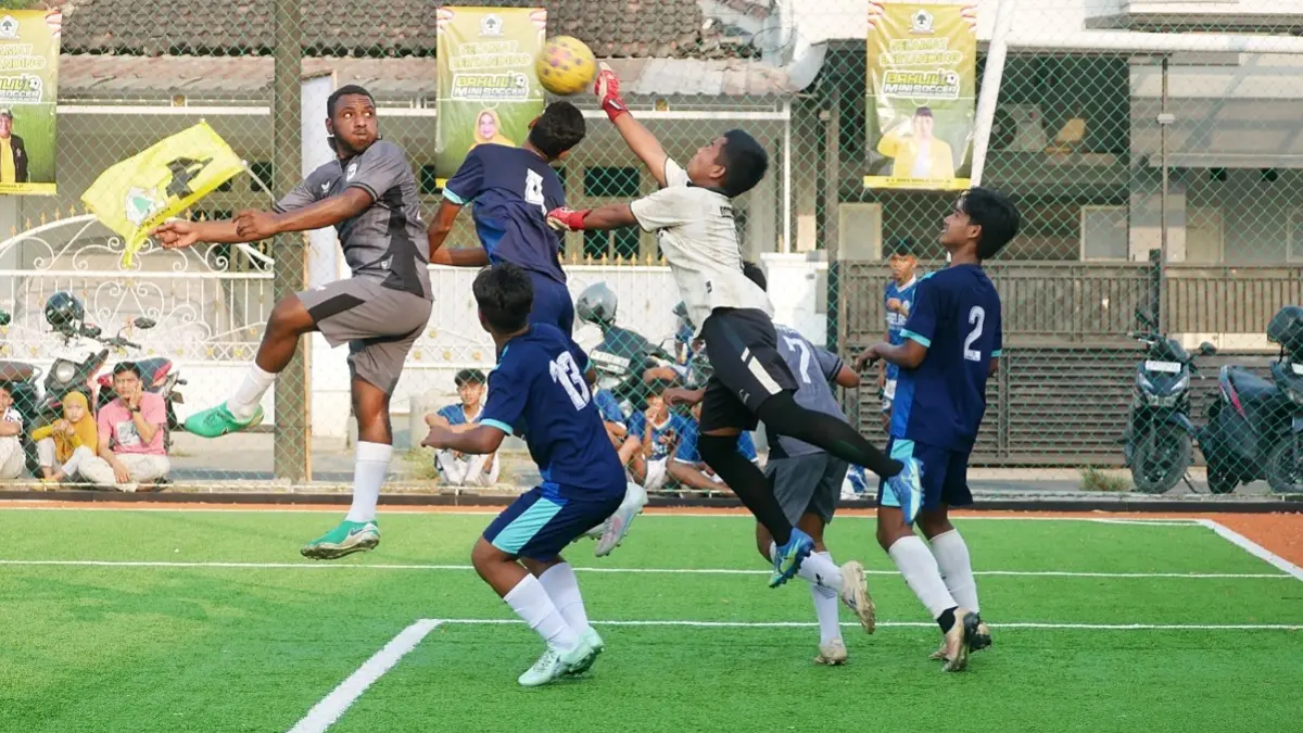 BEREBUT DI UDARA: Pemain SMAN Rambipuji Yunus Fefanya Babingga (kiri), berebut bola atas dengan kiper SMKN 2 Jember dalam pertandingan semifinal Bahlil Mini Soccer Zona 10 Jember, Jumat sore (2/10). Pertandingan itu dimenangkan SMAN Rambipuji dengan skor 2-1. (SIDKIN ALI/RADAR JEMBER)