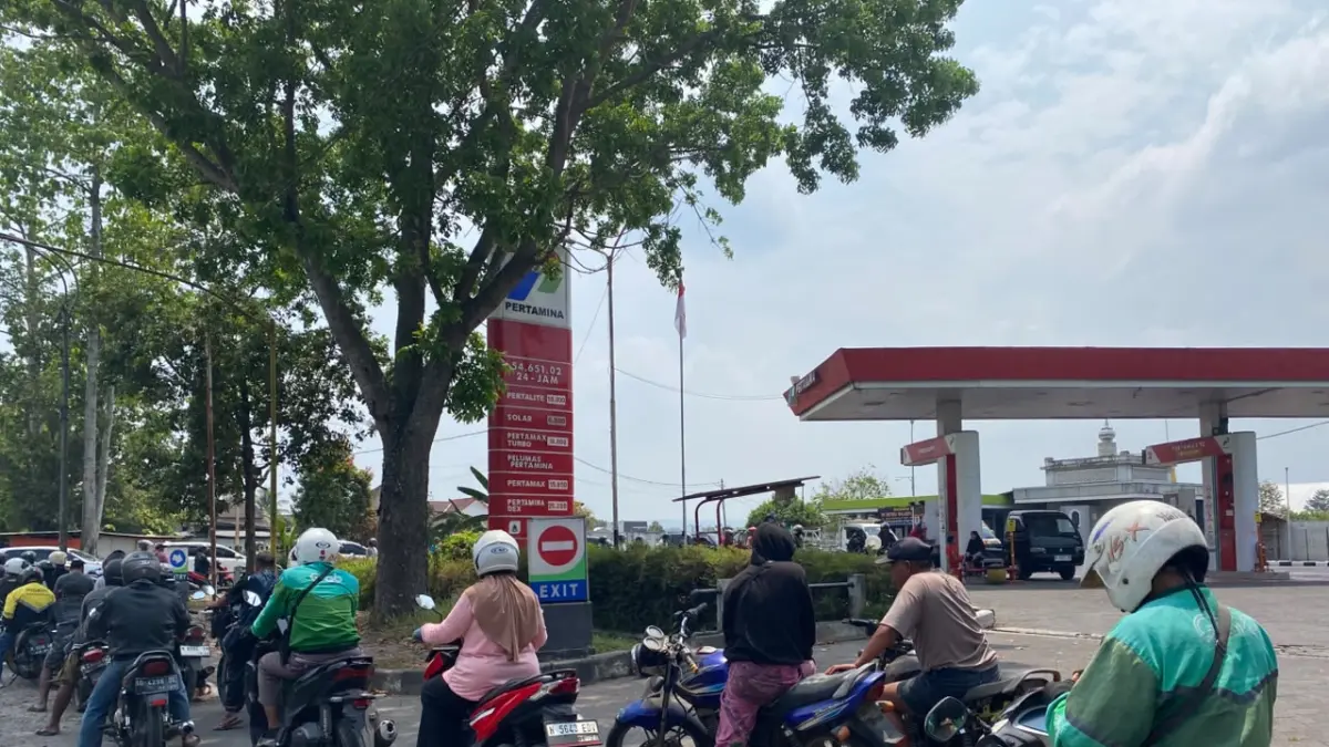 MENGULAR: Antrean kendaraan untuk membeli Pertalite di SPBU Pakisaji memanjang hingga meluber ke jalan, kemarin (9/10).