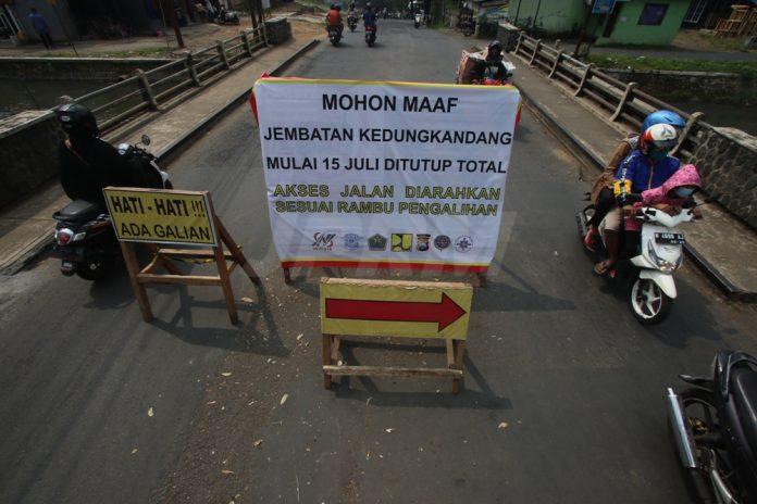Papan pengumuman di pasang di sisi selatan Jembatan Kedungkandang. Foto: Darmono/Radar Malang