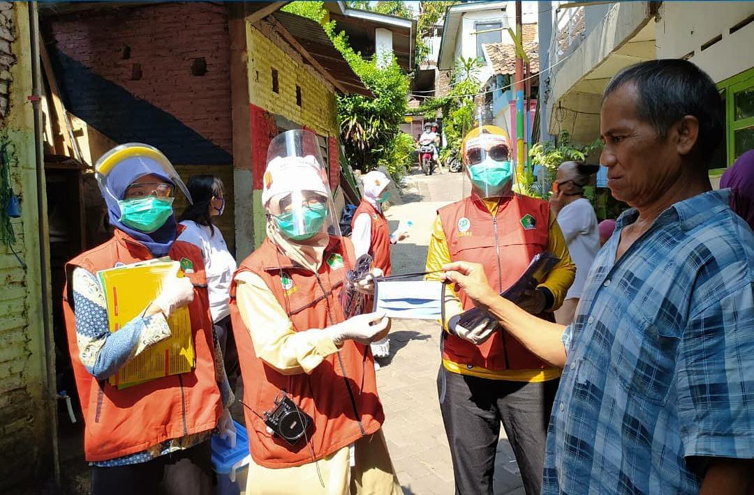 Petugas Puskesmas  membagikan masker ke warga Kota Malang. (Imam Nasrodin/Radar Malang)