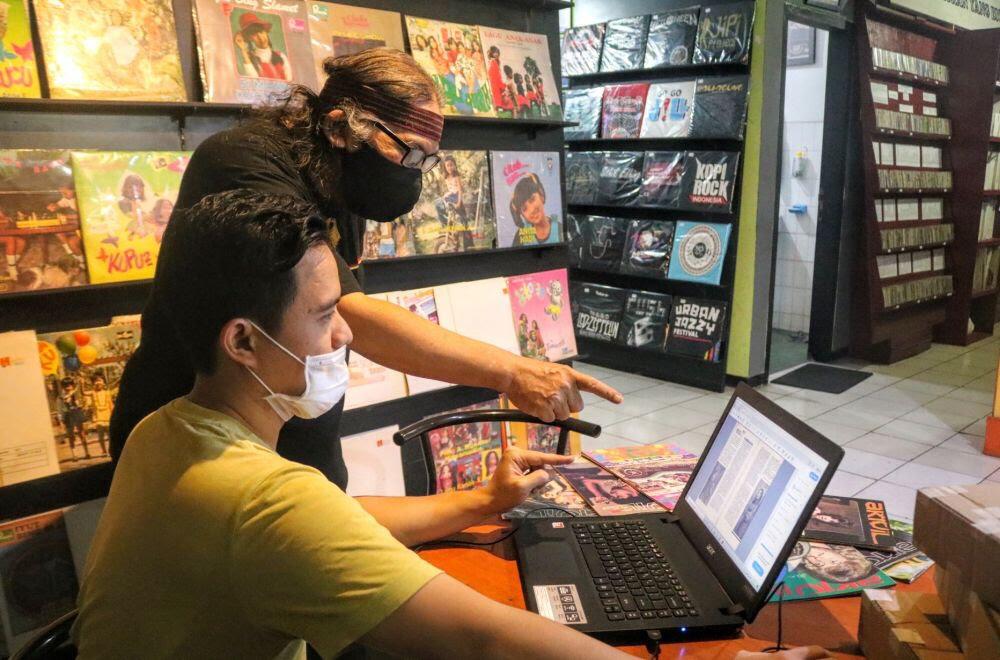 QUALITY CONTROL: Ketua MMI Hengki Herwanto (menunjuk) dan Ari Yusuf Prasetyo ST, bidang quality control sedang berada di ruang pengarsipan saat melakukan pegecekan kualitas foto hasil scan Majalah Aktuil di MMI, Jl Nusakambangan 19 Malang.  (MMI for Radar