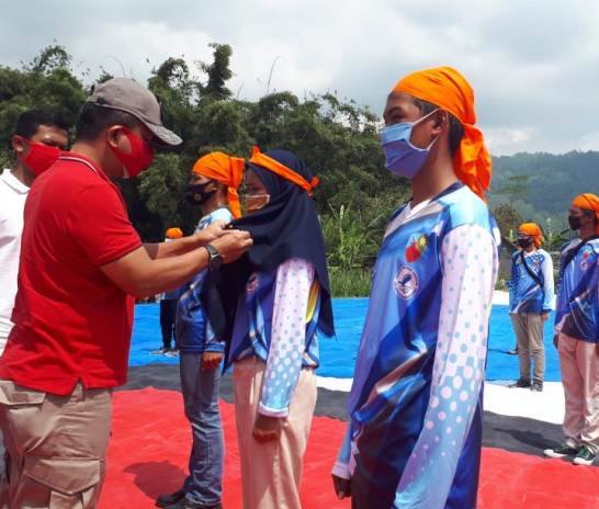 SAH: Komandan Lanud Abdulrachman Saleh Marsma TNI Hesly Paat saat menyematkan brevet paralayang pada salah satu siswa pelatihan, kemarin (15/8). (Foto: Ulfa Afrian /Radar Malang)