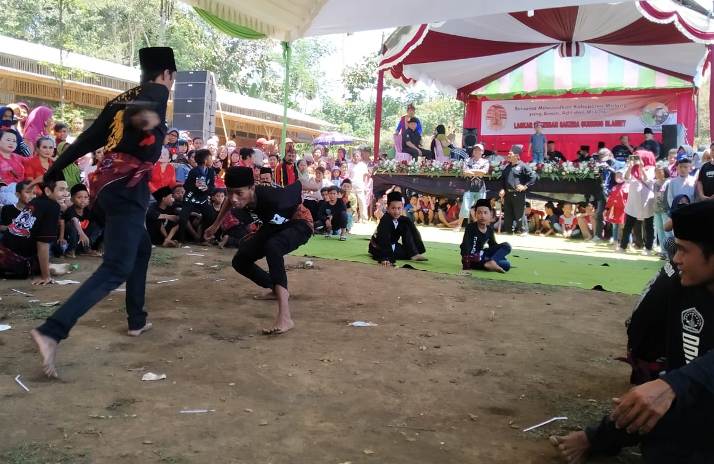 DAYA TARIK: Pencak silat dari Laskar Kesenian Sakera Gunung Slamet menyedot perhatian pengunjung. (Foto: Intan Refa S/Radar Malang)