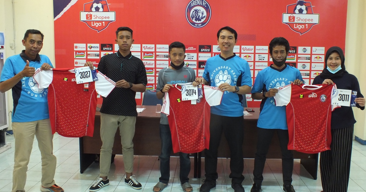 Ketua Pelaksana Arema 33 Anniversary Run 2020 Susanto Setiawan (kiri) saat menyerahkan secara simbolis seragam pelari di Aula Stadion Kanjuruhan, Jumat (7/8).