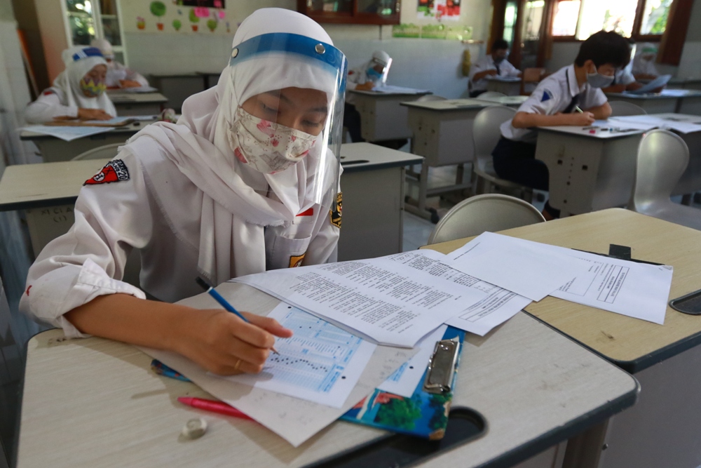 Pelajar SMAN 2 Kota Malang memakai masker dan face shield saat mengikuti pembelajaran di sekolah (Rubianto / Radar Malang)