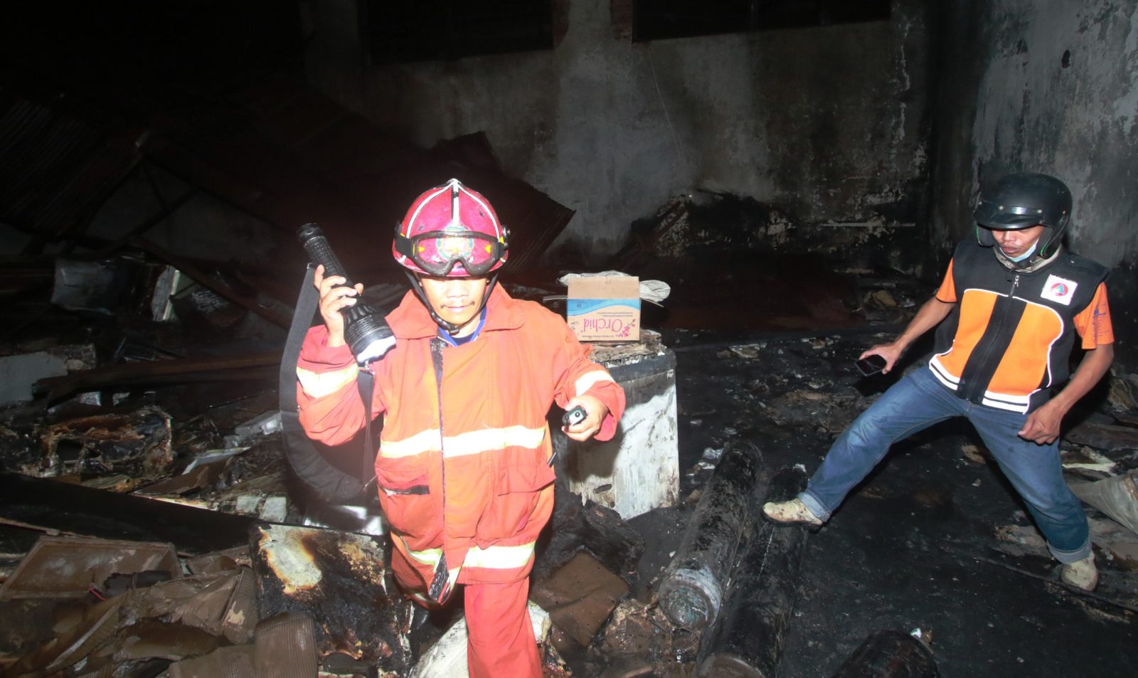 Petugas pemadam kebakaran mengecek gudang milik Toko Elektronik Asia di Jalan Irian Jaya, Klojen, usai kembali terbakar pada Selasa (22/9) malam. (Laoh Mahfud/Radar Malang)