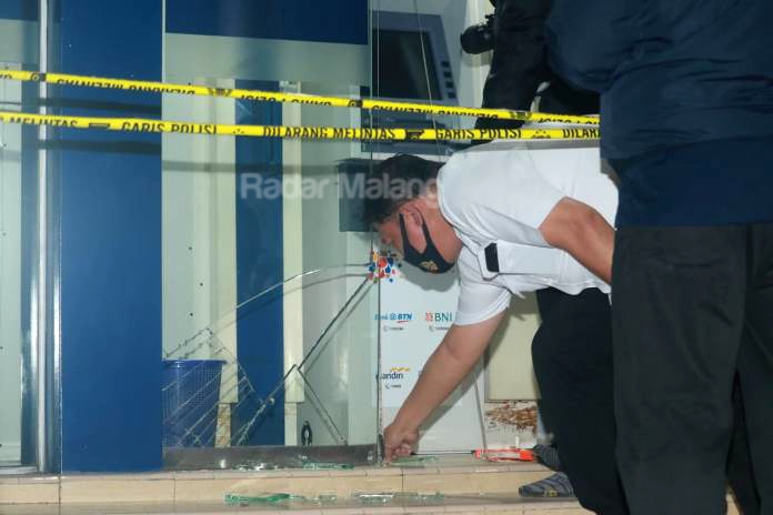 Pintu kaca sebelah kiri mesin Anjungan Tunai Mandiri (ATM) di Jalan Kawi pecah. (Foto: Laoh Mahfud/Radar Malang)