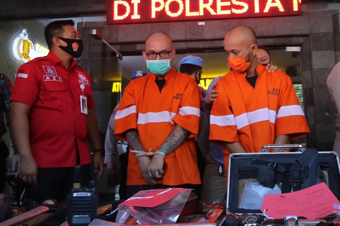 RILIS TERSANGKA: Pelaku kasus  jaringan sindikat senpi ilegal di Malang Raya, Fajrin dan Robby saat dirilis di halaman Mapolresta, Selasa (25/8). (Foto: Darmono/Radar Malang)