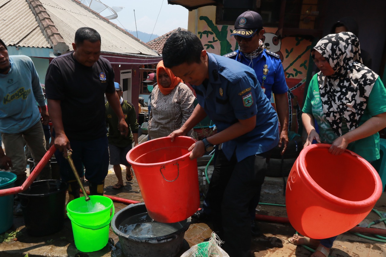 Petugas membagikan air kepada warga yang mengalami krisis air di Sumberbrantas Kota Batu (Foto: Rubianto / Radar Malang)