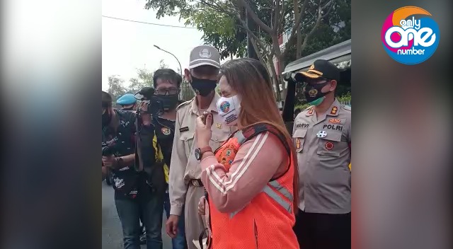 Perempuan bernama Riska, asal Jember, ini dihukum memberi imbauan kepada warga melalui megaphone setelah terjaring operasi yustisi tidak pakai masker di Kota Batu, Senin (14/9). (Nugraha Perdana/Radar Batu)