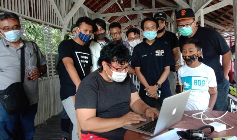 Dr Yuyung Abdi dikerumuni fotografer untuk melihat langsung penilaian  hasil lomba foto model Honda PCX, di Cafe Cokelat Clasic, Sabtu (19/8). (Darmono/Radar Malang)