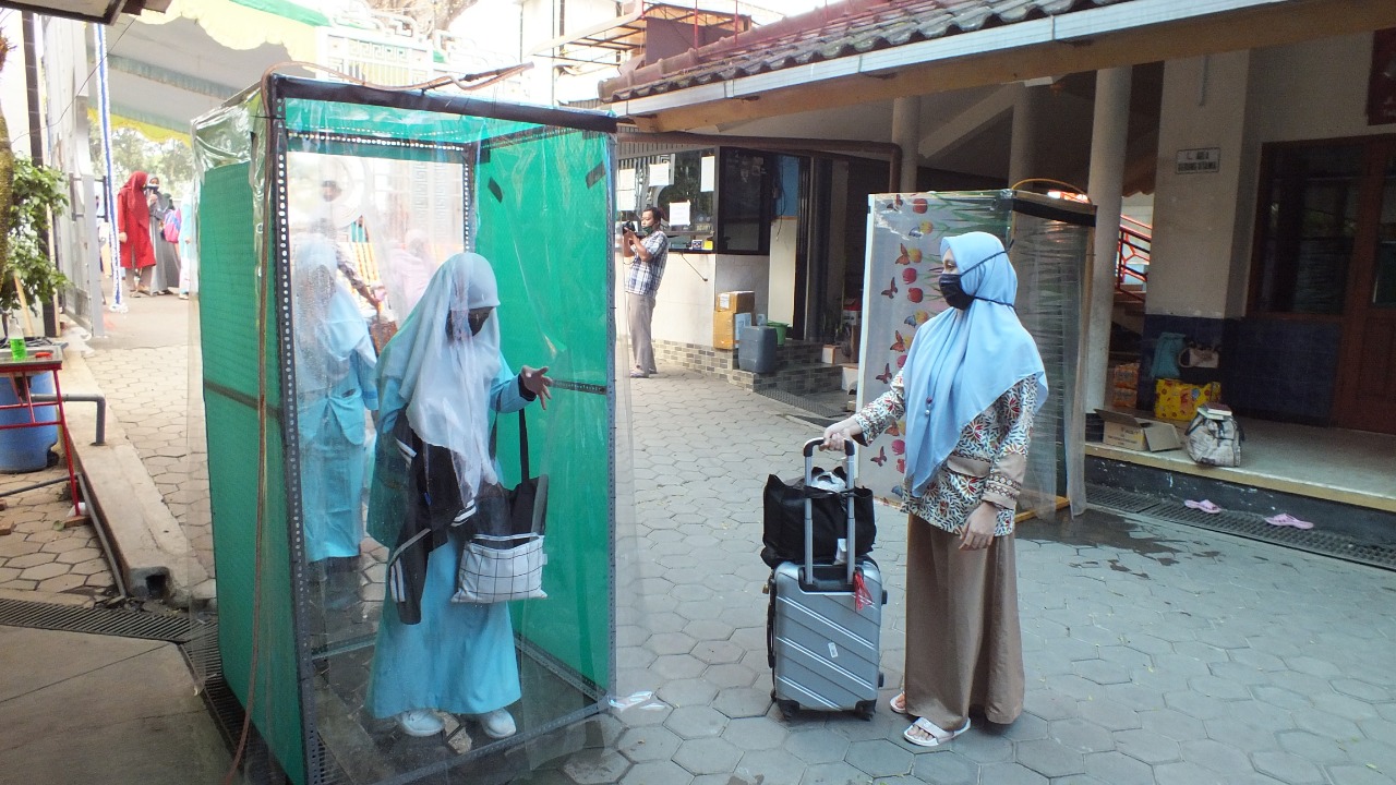 Santri melewati bilik disinfektan sebelum memasuki pondok pesantren (Fikyansyah / Radar Malang)