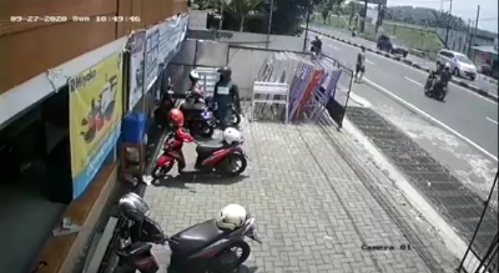 Pelaku curanmor berjaket hitam memakai helm mendekati sasaran di parkiran Toko Ogan, Lawang, Minggu (27/9). (Tangkapan layar)