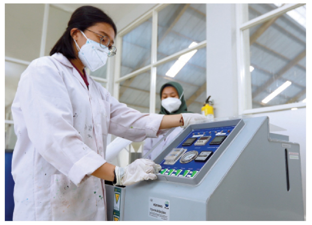 Seorang petugas research and development  sedang mengamati mesin salt spray untuk test korosi cat pada bahan besi atau metal di PT. Inti Daya Guna Aneka Warna (Indana),  Senin (5/10) kemarin.  (Rubianto / Radar Malang)