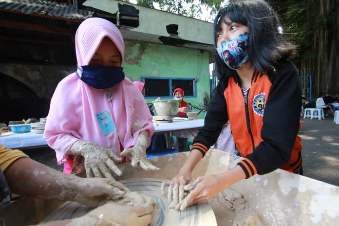 Praktik langsung membuat keramik membuat senang anak-anak di Festival Keramik Dinoyo, Minggu (11/10).(Laoh Mahfud/Radar Malang)