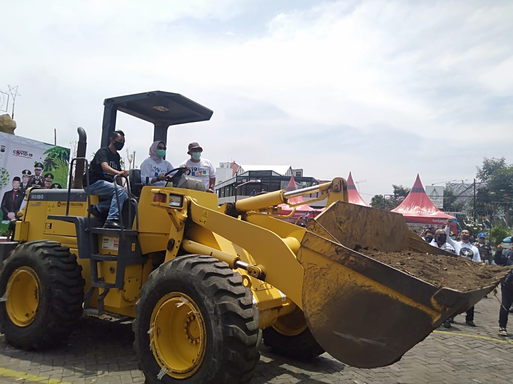 Wali Kota Batu, Dewanti Rumpoko saat mengoperasikan kendaraan berat dalam acara penanaman pohon. (Imam N / Radar Malang)