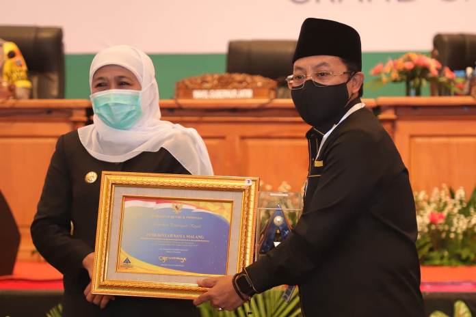 Wali Kota Malang (kanan) menerima penghargan Opini WTP yang secara simbolis diserahkan Gubernur Jatim  Senin (19/10) di Surabaya. (Istimewa)