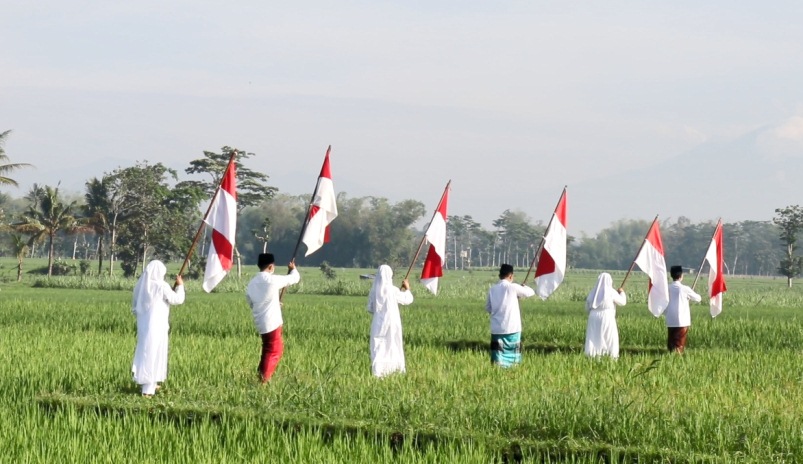 Para pelajar berjalan di area persawahan. (istimewa)
