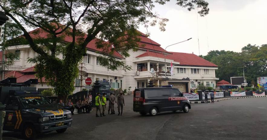Aparat sudah bersiaga di depan Gedung DPRD Kota Malang sejak pukul 09.00 untuk mengantisipasi rencana demo oleh mahasiswa dari PMII dan GMNI, siang ini (23/10). (Errica Vannie A/Radar Malang)