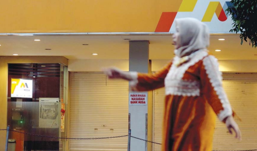 warga melintas di depan kantor Bank Mega KCP Kyai Tamin Malang. (Darmono/Radar Malang)