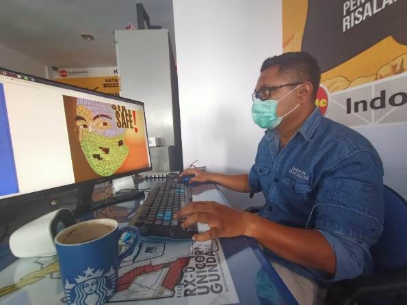 Rahardian Bagaskoro, juri lomba Poster LO Kreatif 2020, serius menyeleksi hasil karya peserta yang masuk panitia, Selasa ( 10/11). (Darmono/Radar Malang)