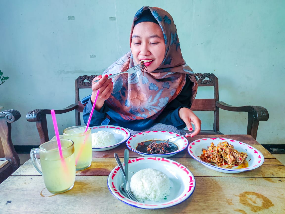 Salah satu pengunjung menikmati menu di Sego  Lombok Mbah Buyut (Aprilia Nur Azizah / Radar Malang)