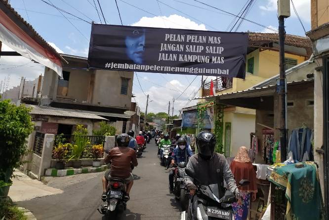 Spanduk yang menampilkan wajah tokoh horor Indonesia Suzana di Jembatan Pelor Kota Malang. (Errica Vannie A/Radar Malang)