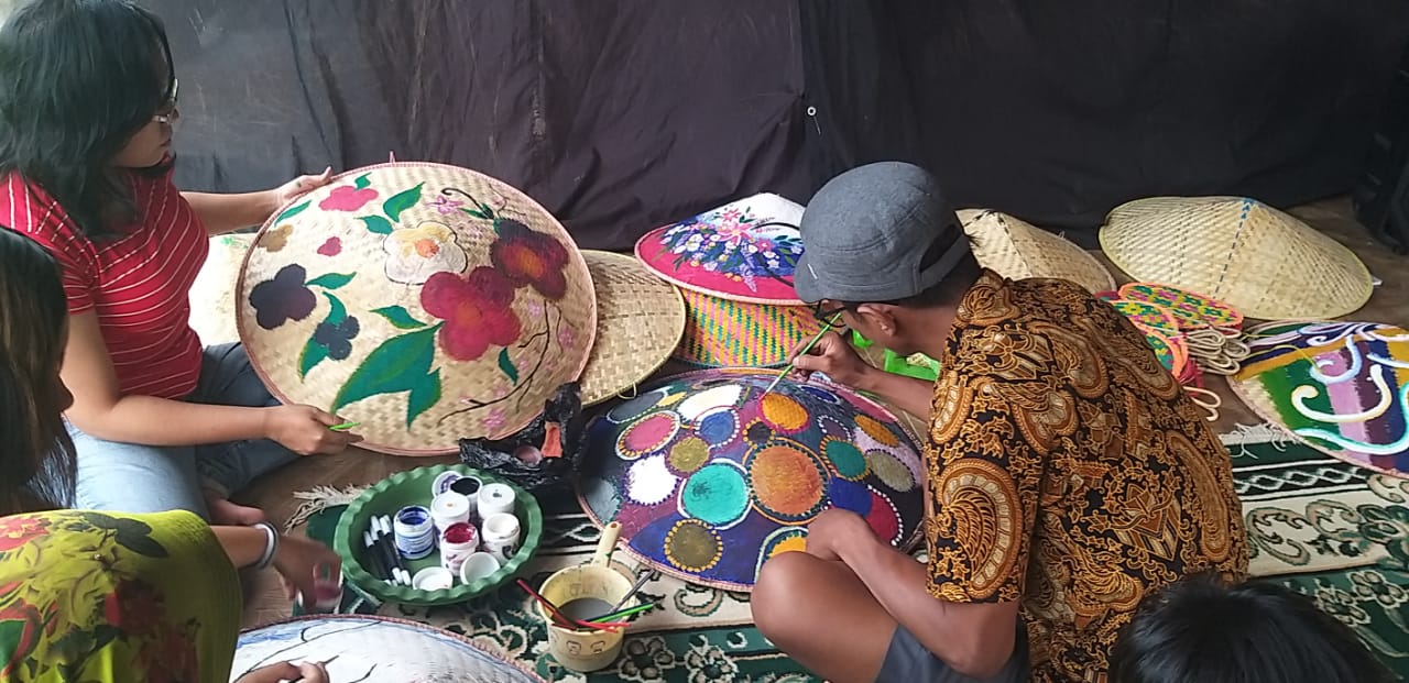 Rombongan dari sentra Perajin Sentra Anyaman Bambu Lamongan diajak praktik melukis bersama di media caping di Kampung Budaya Polowijen, Minggu (22/11).  . (Istimewa)