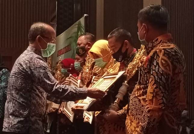 Ketua PTA Surabaya Drs H Mohammad Yamin Awie SH MH memberikan penghargaan kepada Pengadilan Agama di Jawa Timur yang memiliki kinerja terbaik dalam berbagai bidang di Hotel Golden Tulip Resort Batu Malang. Selasa (24/11) malam. (Nugraha Perdana/Radar Mala