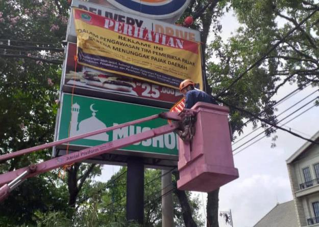 Reklame yang menunggak pajak akan ditempeli stiker atau banner dan akan dilepas segelnya setelah tunggakan pajaknya dibayarkan. (Istimewa)