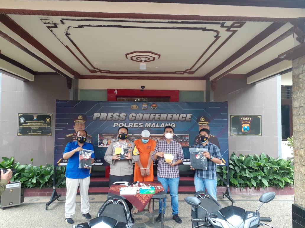 Pelaku perampasan yang mengaku polisi (tengah) diamankan bersama sejumlah barang bukti HP rampasan. (Septianur Aji Hariyanto/Radar Malang).