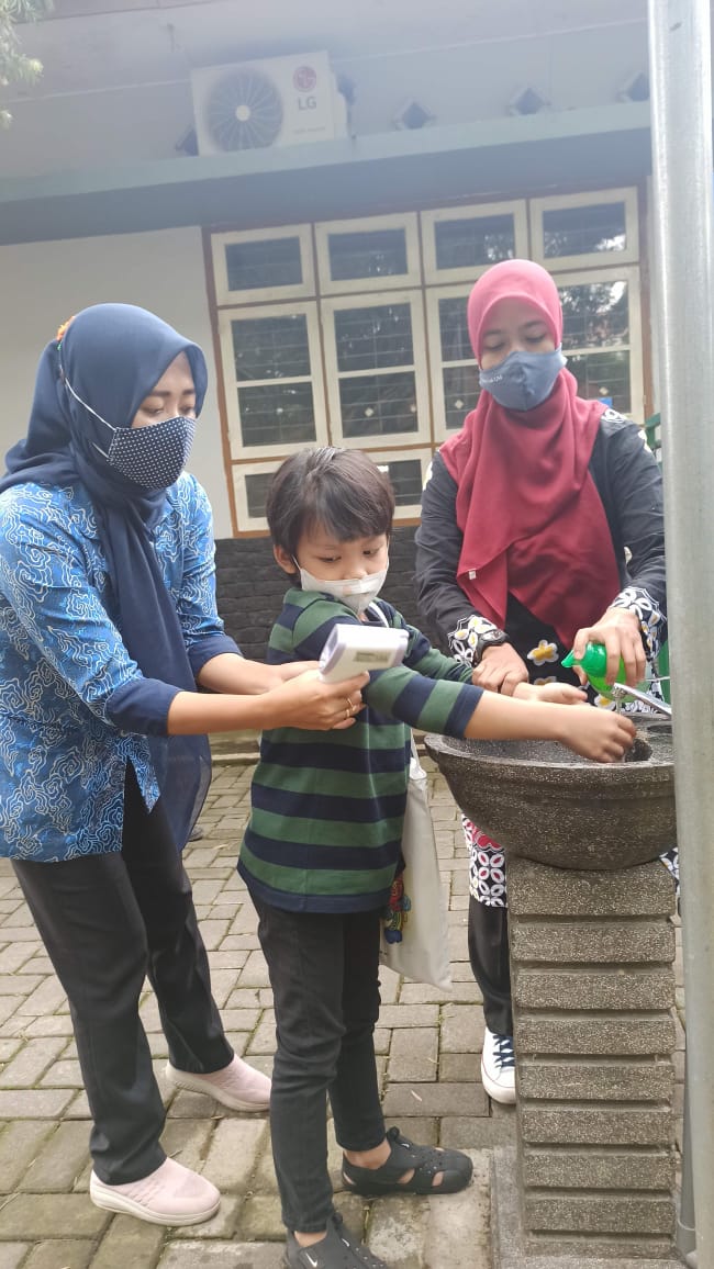 ILUSTRASI: Salah satu siswa SLB Autis Lab UM diajari mencuci tangan dan dikenalkan dengan thermogun. Dok/Radar Malang)