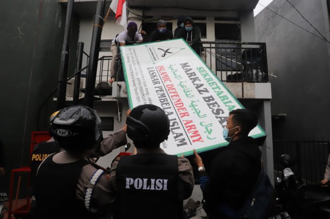 Personel TNI dan Polri saat melakukan pencopotan papan informasi FPI.(jawapos.com)