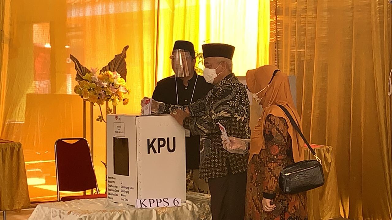 Sanusi (tengah) dan istri saat mencoblos di TPS yang berada dekat kediamannya di Gondanglegi (Fuad Hassan / Radar Malang)