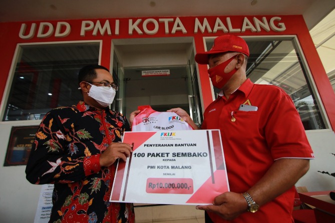 Ketua FKIJK Malang Sugiarto Kasmuri menyerahkan bantuan sembako secara simbolis kepada Sekretaris II PDDI Kota Malang Puryadi di kantor PMI, Jumat (11/12).(Laoh Mahfud/Radar Malang)