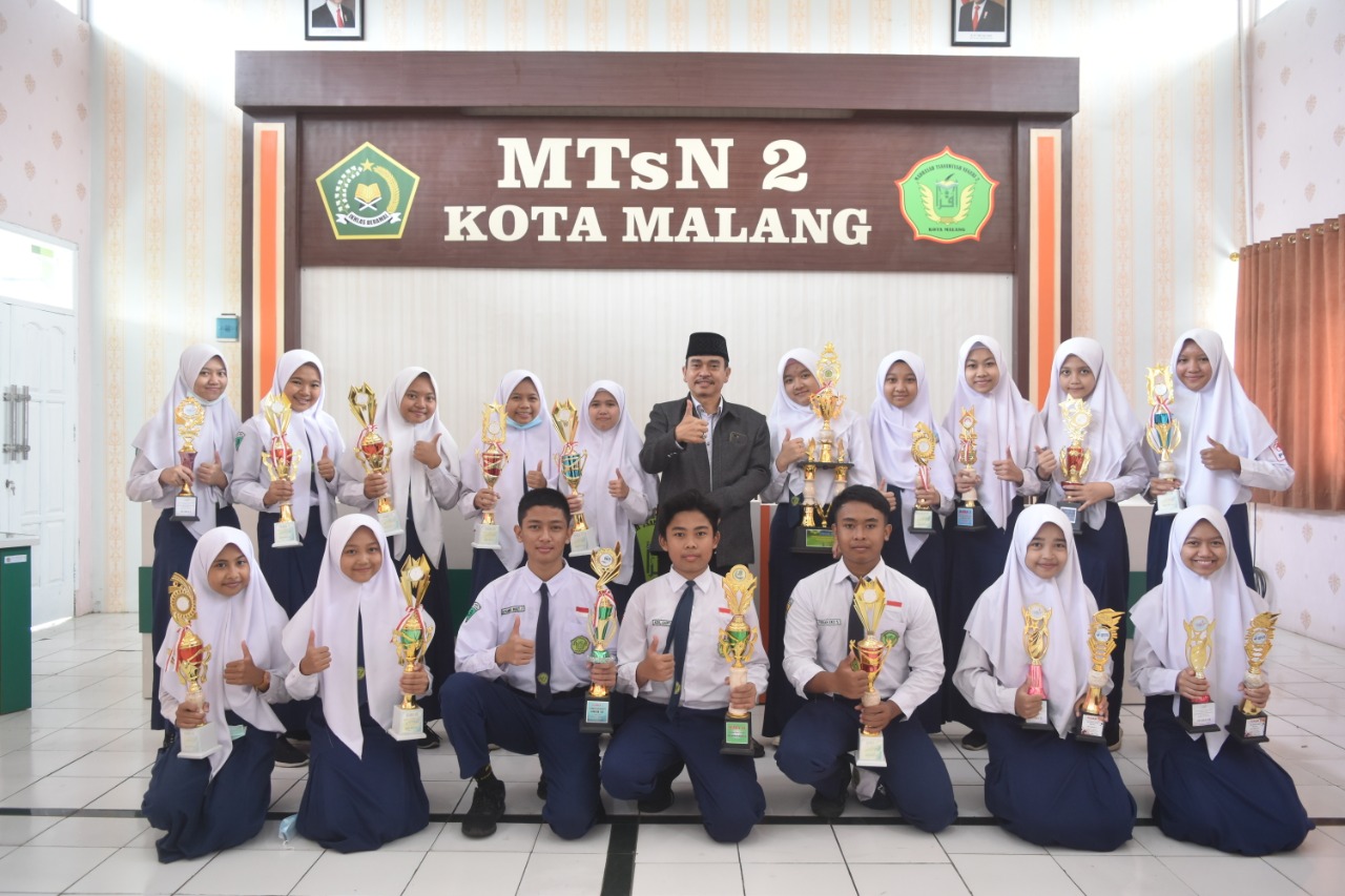 Kepala MTsN 2 Kota Malang Dr H Subhan SPd MSi berfoto bersama para siswa dan siswi berprestasi. (MTsN 2 Kota Malang for Radar Malang)