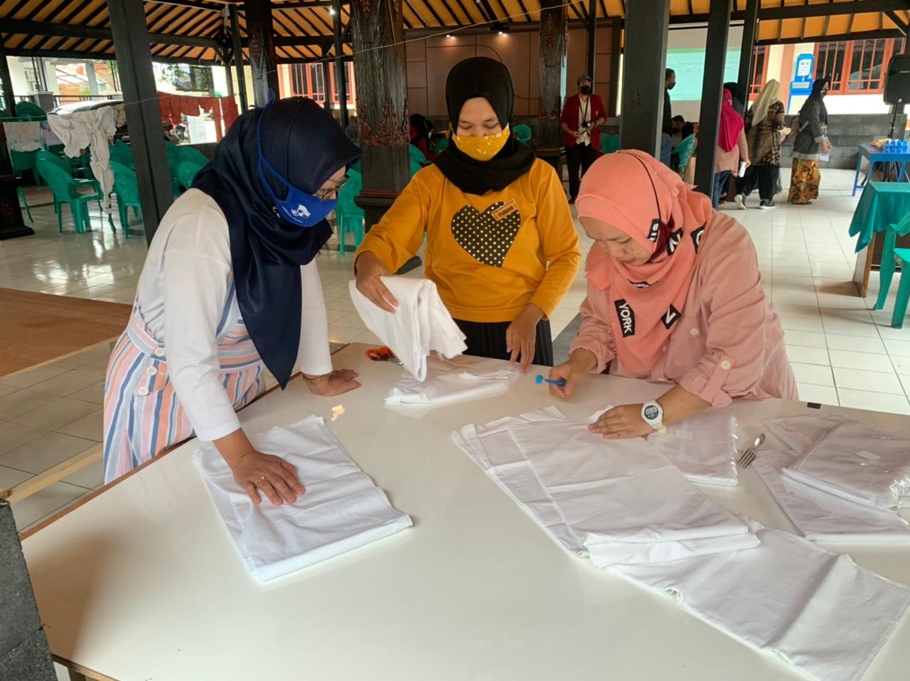 Sejumlah ibu-ibu sedang menyiapkan kain yang akan dijadikan batik kembang tanjung. (Nugraha Perdana/Radar Malang)