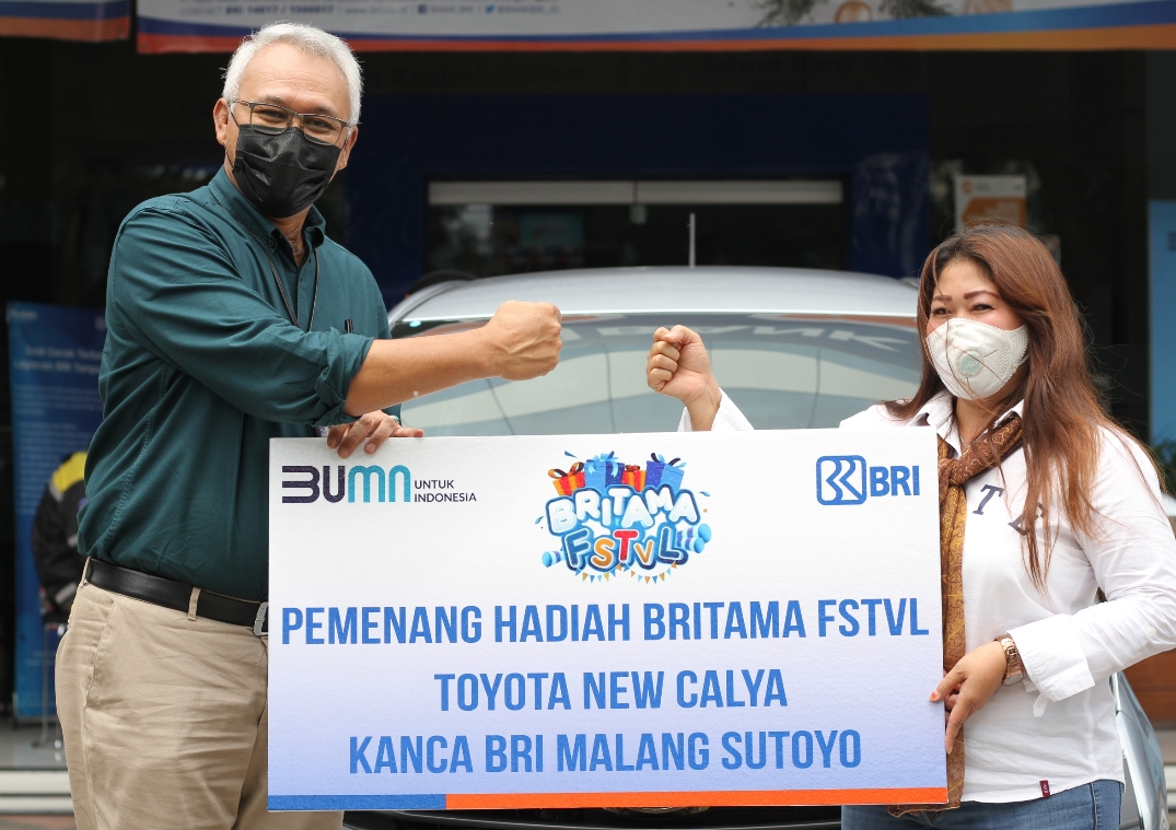 Pemimpin BRI KC Malang Sutoyo Arys Koeswirjatno (kiri) menyerahkan hadiah mobil kepada pemenang undian Britama FSTVL tahap pertama, Christian Sulistyorini. (Rofia Ismaniar / Radar Malang)