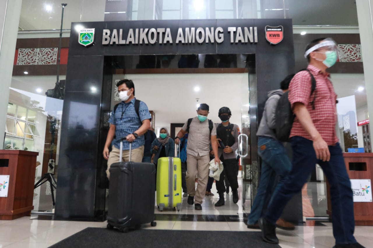 Petugas KPK membawa koper yang diduga berisi dokumen barang bukti, keluar dari Balaikota Among Tani, Rabu (6/1). (Rubianto / Radar Malang)
